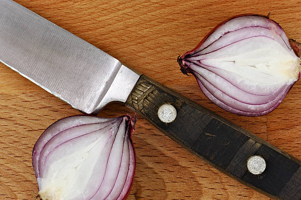 istock Knife with two slices of red onion on cutting board 478128549