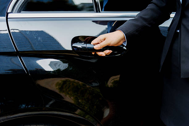 Chauffeur open car door Female chauffeur opening a luxury car door. door attendant photos stock pictures, royalty-free photos & images