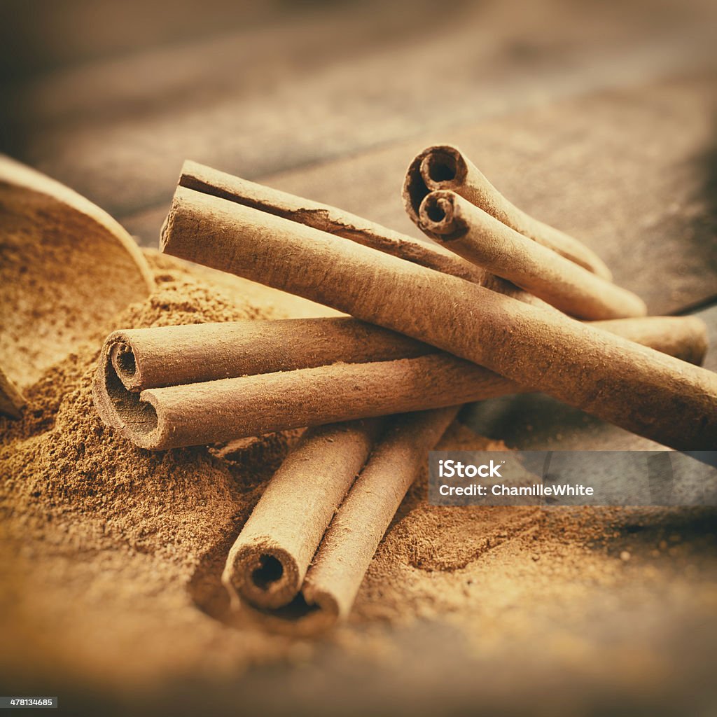 Vintage stylized photo of Cinnamon sticks and powder Vintage stylized photo of Cinnamon sticks and cinnamon powder on wooden plank Cinnamon Stock Photo