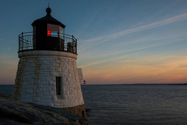 istock Lighthouse at Sunset as Sailboat Approaches 478138494