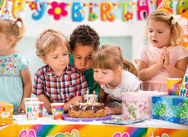 niños soplando velas de cumpleaños fiesta de cumpleaños. - birthday cake five people party fotografías e imágenes de stock