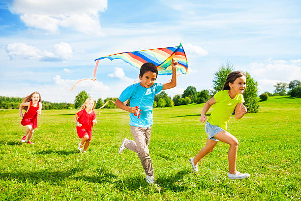 istock Group of kids run with kite 478145143