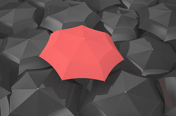 istock red umbrella among black umbrellas 478145420