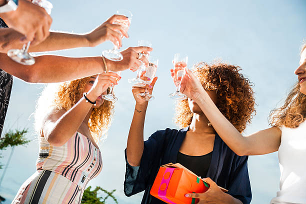 Happy friends at Birthday party dancing and drinking together outdoor.