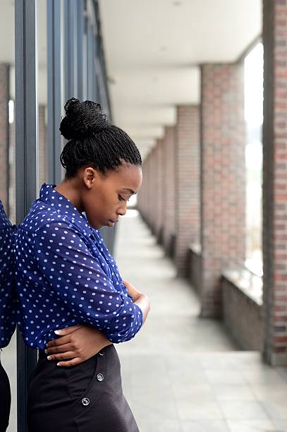 istock Depressed office worker stares at floor with arms folder 478151774
