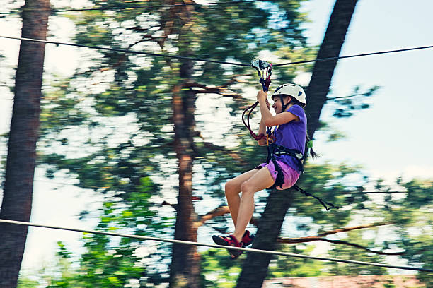 kleines mädchen mit futter in den adventure park - ziplining zip line outdoors zip lining stock-fotos und bilder