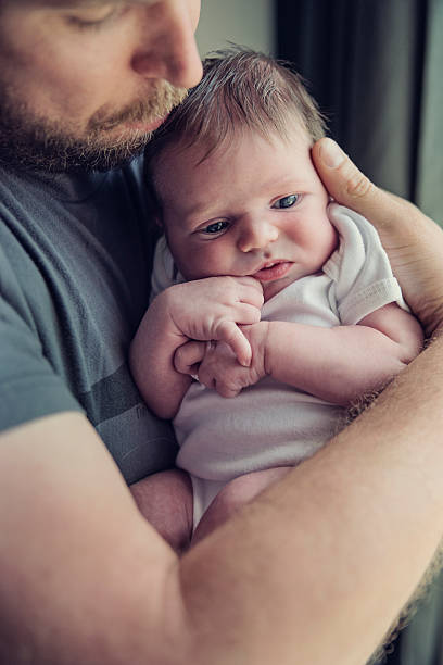 istock Young bearded dad tenderly holding his newborn baby. 478154536