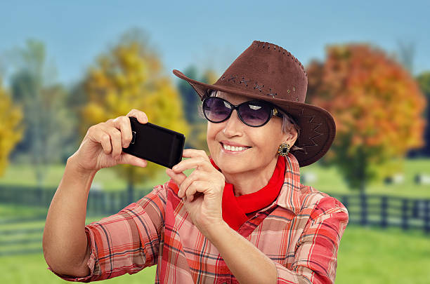 una cowgirl rendendo selfie - shirt checked women wild west foto e immagini stock