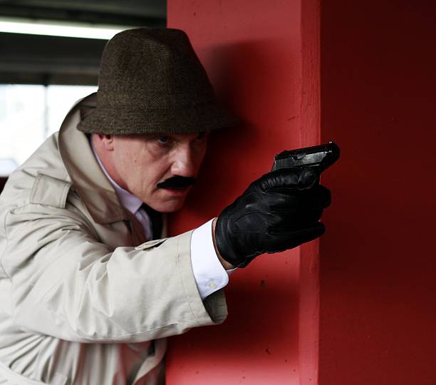 hombre maduro vestido como un arma apuntando detective - spy gun men humor fotografías e imágenes de stock