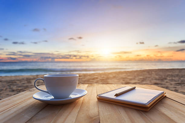 istock Coffee cup on wood table at sunset or sunrise beach 478158548