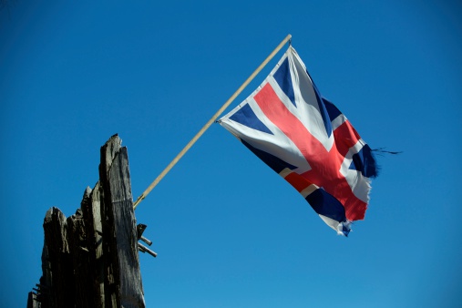 A tattered Union Jack / British Flag flying over the historic fort at Jamestown, Virginia.