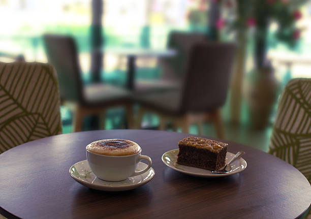 Cup of coffee and a plate of cake on the table in cafe