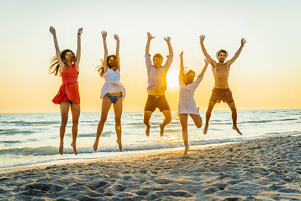 istock Five happy friends jumping on the beach for summer 478163508