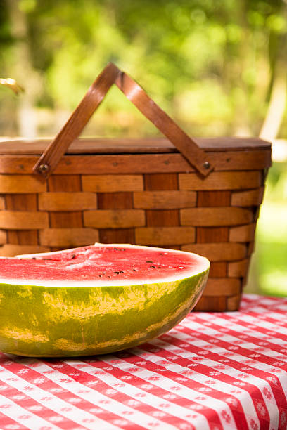 スライスのスイカ屋外でのピクニックテーブルを配しております。夏ます。バスケットます。 - picnic watermelon tablecloth picnic table ストックフォトと画像