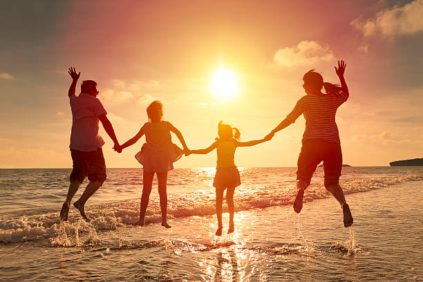 istock happy family jumping together on the beach 478165662