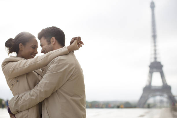 coppia abbracciare vicino alla torre eiffel, parigi, francia - paris france heterosexual couple couple french culture foto e immagini stock