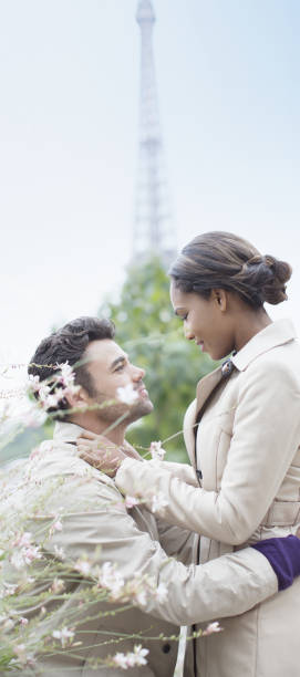 coppia, abbracciare nella parte anteriore della torre eiffel, parigi, francia - paris france heterosexual couple couple french culture foto e immagini stock