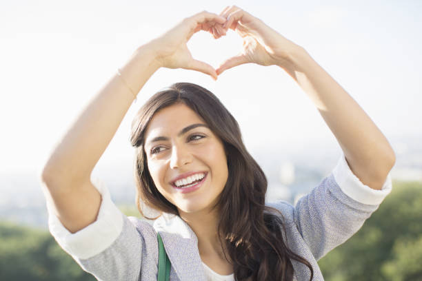 istock Woman making heart-shape with hands outdoors 478167363