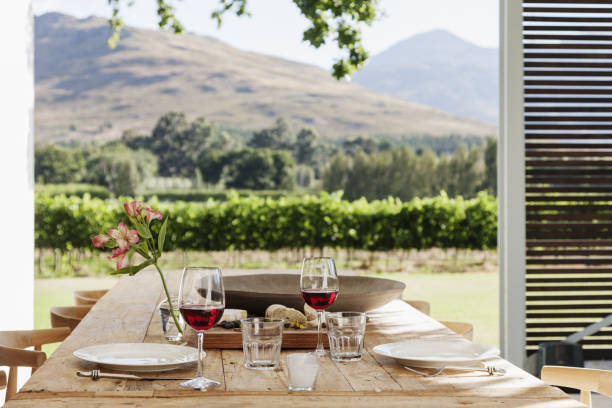 Dining table and chairs on luxury patio overlooking vineyard stock photo