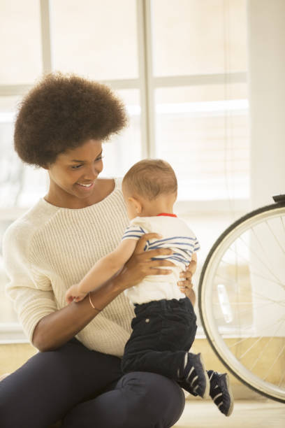 istock Mother holding baby boy on floor 478168639