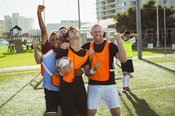 fußball spieler jubeln auf feld - soccer player soccer men smiling stock-fotos und bilder