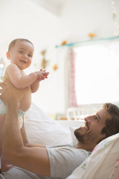 istock Father holding baby boy on sofa 478168979