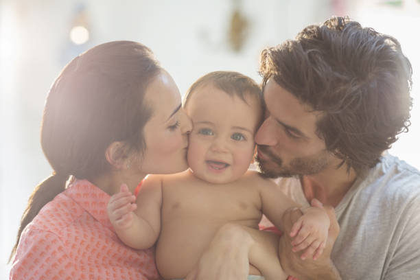 istock Parents kissing baby boy's cheeks 478169177