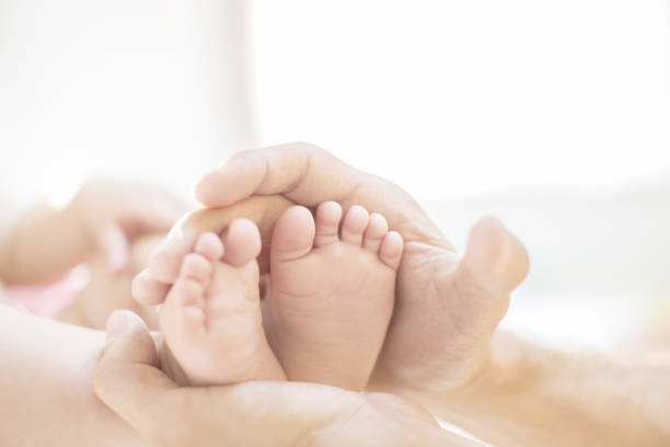 istock Father cradling baby boy's feet 478169255