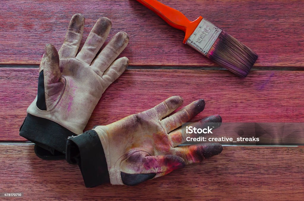 pair of stained work gloves and a paint brush a pair of stained work gloves and a paint brush 2015 Stock Photo