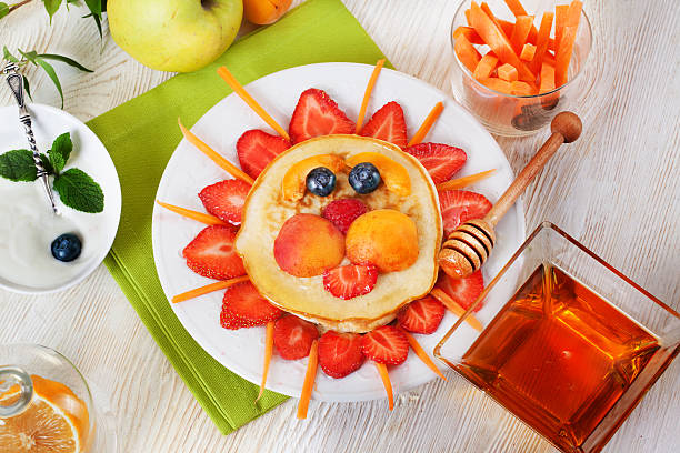 Children's breakfast pancakes smiling face of the sun lion stock photo