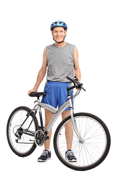 istock Senior biker standing behind a bicycle and smiling 478184094