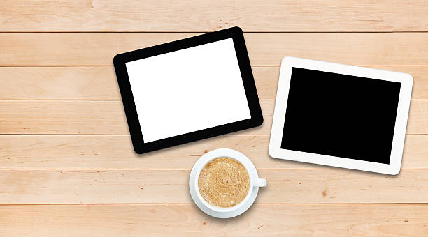 istock Two tablet PCs and coffee on a wooden table 478187132
