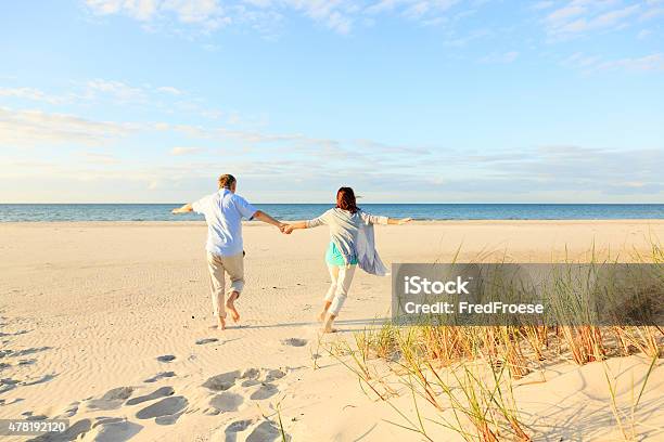 Happy Mature Couple Outdoors On The Beach Stock Photo - Download Image Now - 2015, 50-59 Years, Active Lifestyle