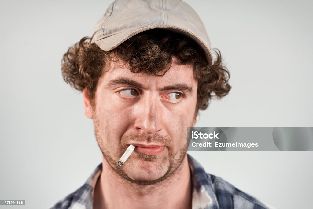 Disapproving Redneck Disapproving redneck glances over his shoulder while smoking his cigarette 2015 Stock Photo