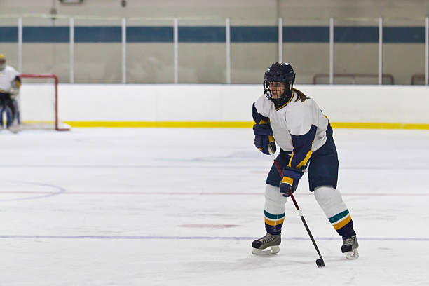 Female ice hockey player skating during the game stock photo