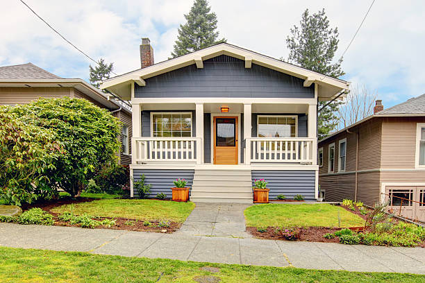 Small blue house with white porch exterior. Small simple blue grey craftsman style house with white porch. pacific northwest stock pictures, royalty-free photos & images