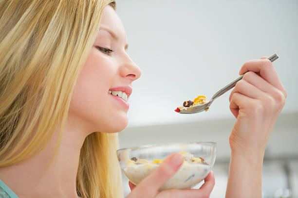 istock young woman eating healthy breakfast 478198393