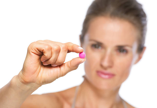 istock closeup on young woman showing pill 478199349