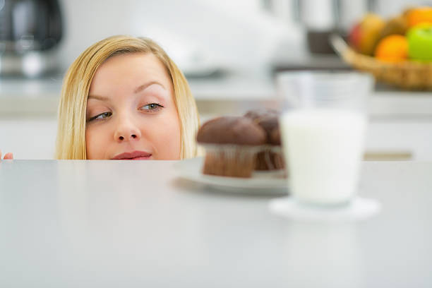 istock young woman looking on chocolate muffin 478199385