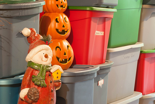 Plastic storage bins, filled with decorations for various holidays.