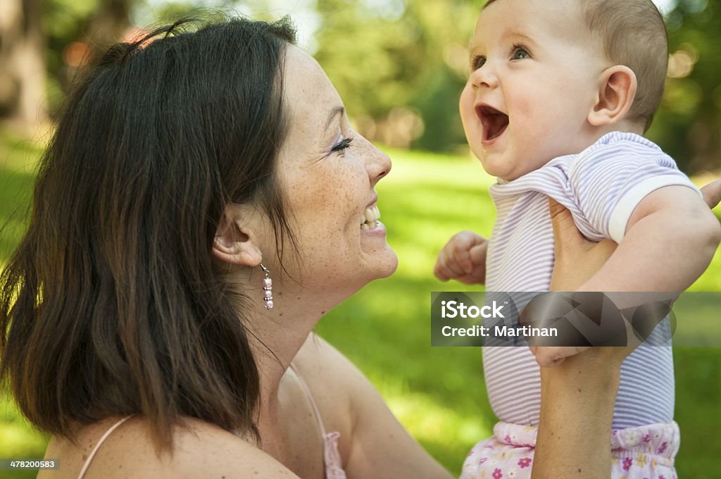 Felice madre con il Suo bambino sorridente - Foto stock royalty-free di Abbracciare una persona