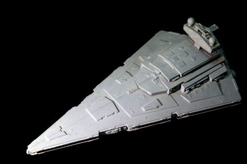 Vancouver, Canada - May 1, 2011: The wedge shape of a model Star Destroyer posed against a black background. The model is produced by the AMT model company and represents a spaceship from the Star Wars movie series.