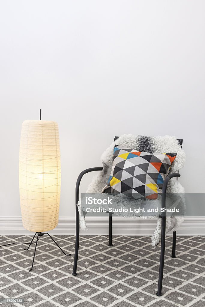 Chair with bright cushion and elegant floor lamp Home decorating. Chair with bright cushion and elegant floor lamp. Rug Stock Photo