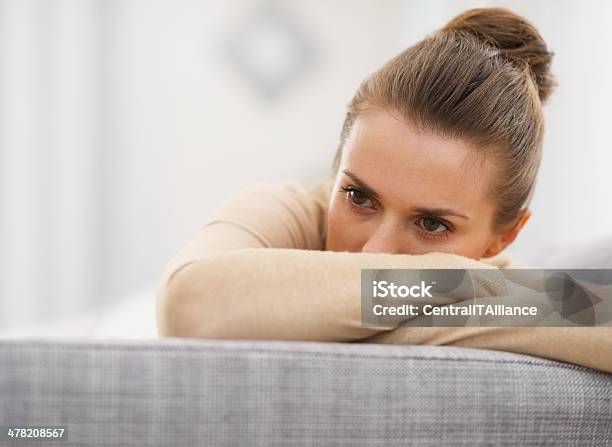 Photo libre de droit de Stressé De Jeune Femme Assise Sur Un Canapé banque d'images et plus d'images libres de droit de Femmes - Femmes, Tristesse, Dépression