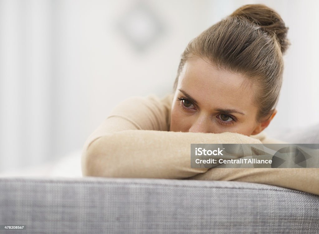 stressed young woman sitting on sofa Stressed young woman sitting on sofa Women Stock Photo