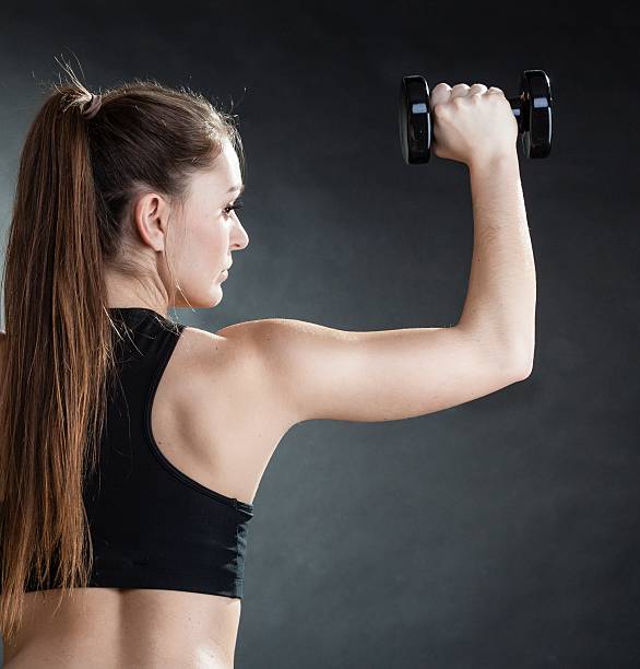 istock Fitness girl training shoulder muscles lifting dumbbells 478210149