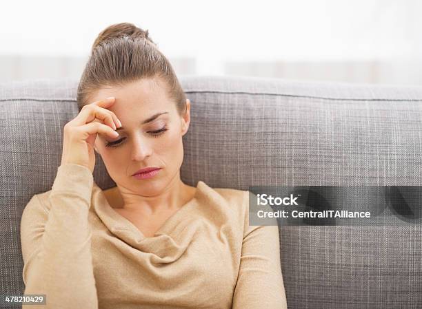 Stressed Young Woman Sitting On Sofa Stock Photo - Download Image Now - Adult, Beautiful People, Beauty