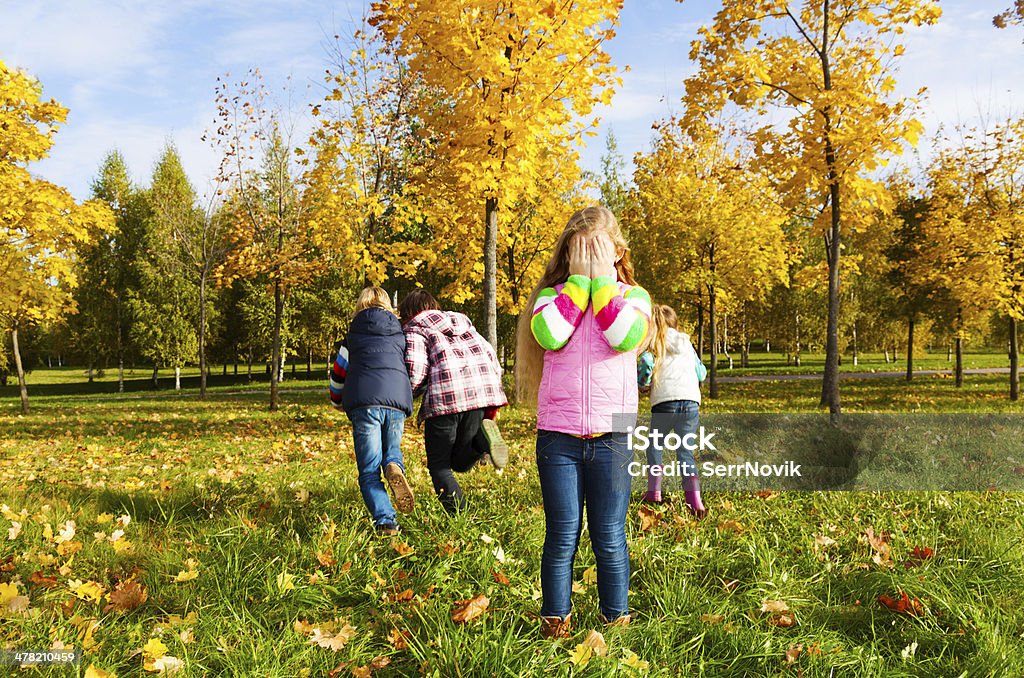 Hide and seek game Kids play hide and seek with girl counting and friends running away Child Stock Photo