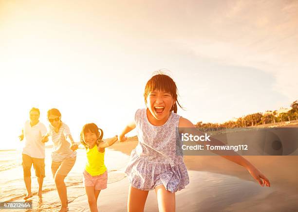 Happy Family Running On The Beach Stock Photo - Download Image Now - Running, Asian and Indian Ethnicities, Family