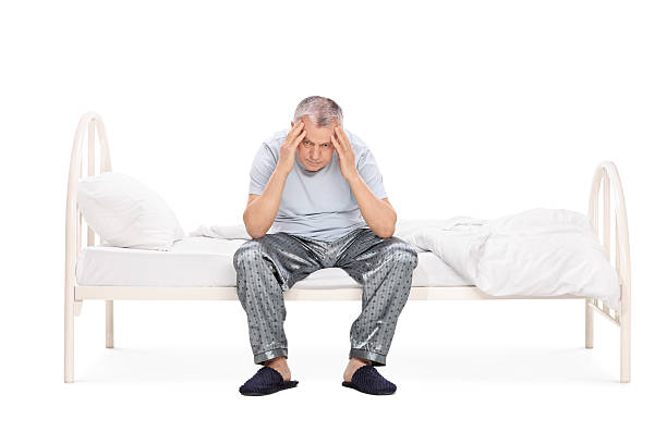 istock Frustrated senior sitting on a bed in his pajamas 478216454
